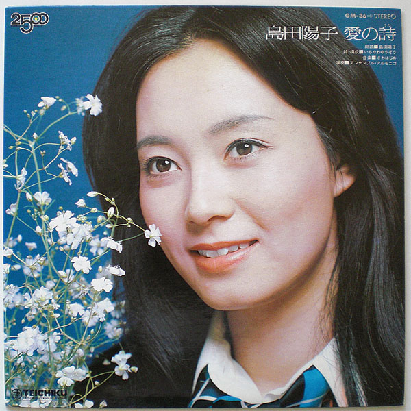 白い花と一緒に写る制服姿で笑顔の島田陽子